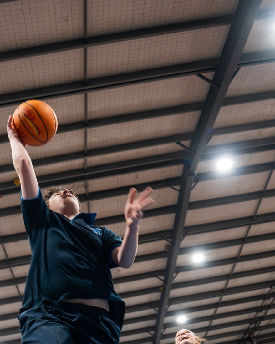 Student reaching up for a layup